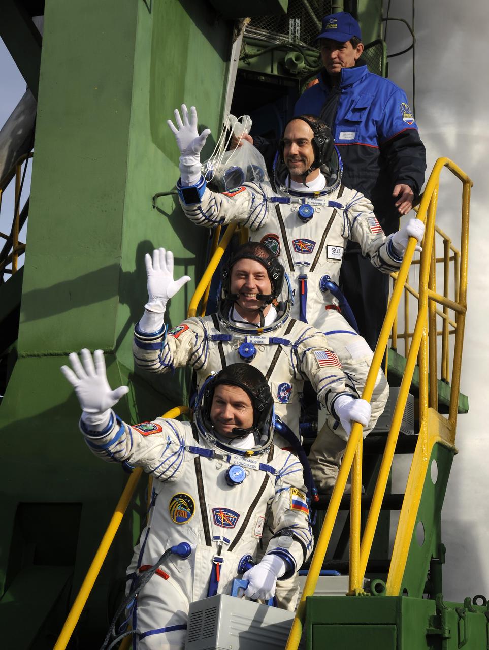 Expedition 18 Flight Engineer Yuri V. Lonchakov, bottom, Expedition 18 Commander Michael Fincke and American spaceflight participant Richard Garriott, top, wave farewell from the steps of the Soyuz launch pad prior to their launch in the Soyuz TMA-13 spacecraft, Sunday, Oct. 12, 2008 from the Baikonur Cosmodrome in Kazakhstan. The three crew members are scheduled to dock with the International Space Station on Oct. 14. Fincke and Lonchakov will spend six months on the station, while Garriott will return to Earth Oct. 24 with two of the Expedition 17 crew members currently on the International Space Station. Photo Credit: (NASA/Bill Ingalls)