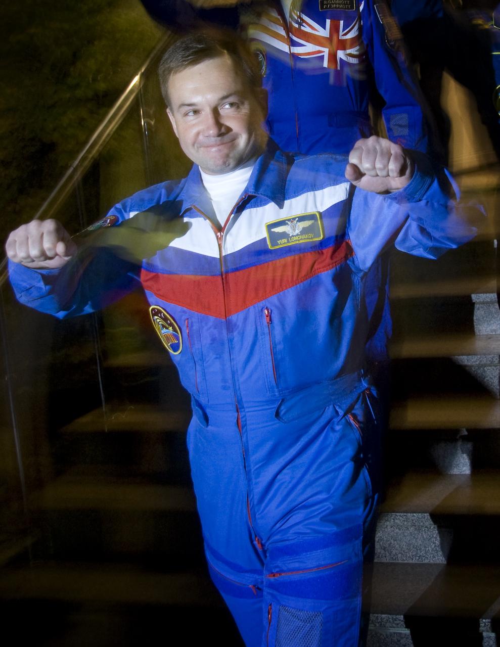 Expedition 18 Flight Engineer Yuri V. Lonchakov pumps his fists as he and fellow crew members Expedition 18 Commander Michael Fincke and American spaceflight participant Richard Garriott depart the Cosmonaut hotel for the bus ride to building 254 where the crew will don their spacesuits, Sunday, Oct. 12, 2008, in Baikonur, Kazakhstan.  The three crew members are scheduled to dock with the International Space Station on Oct. 14.  Fincke and Lonchakov will spend six months on the station, while Garriott will return to Earth Oct. 24 with two of the Expedition 17 crew members currently on the International Space Station.  Photo Credit: (NASA/Victor Zelentsov)