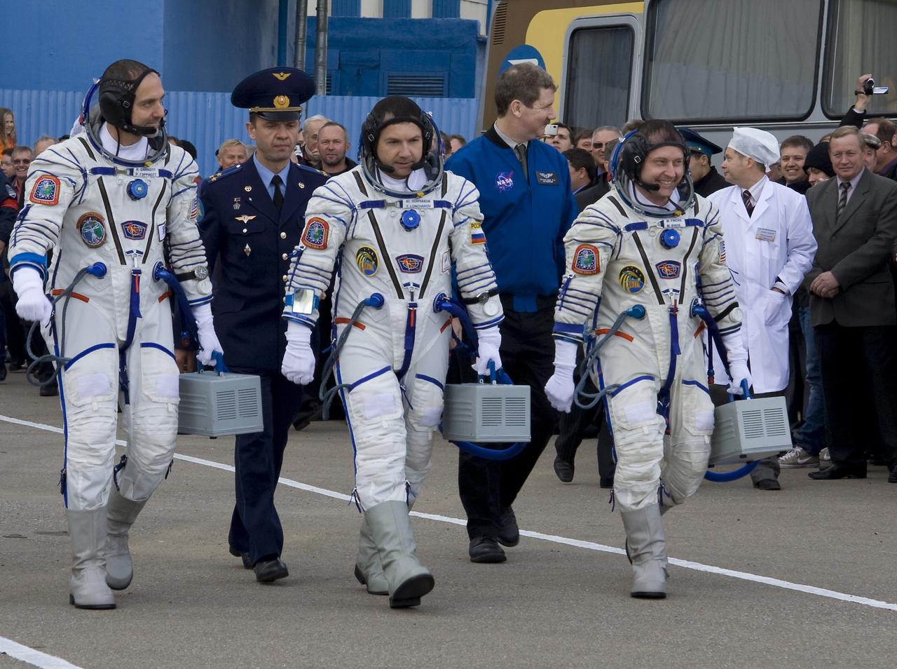 American spaceflight participant Richard Garriott, left, Expedition 18 Flight Engineer Yuri V. Lonchakov and Expedition 18 Commander Michael Fincke, right, depart building 254 where the crew donned their spacesuits prior to launch in the Soyuz TMA-13 spacecraft, Sunday Oct. 12, 2008 from the Baikonur Cosmodrome in Kazakhstan. The crew is scheduled to dock to the International Space Station on Oct. 14. Fincke and Lonchakov will spend six months on the station, while Garriott will return to Earth Oct. 24 with two of the Expedition 17 crewmembers currently on the International Space Station. Photo Credit: (NASA/Victor Zelentsov)