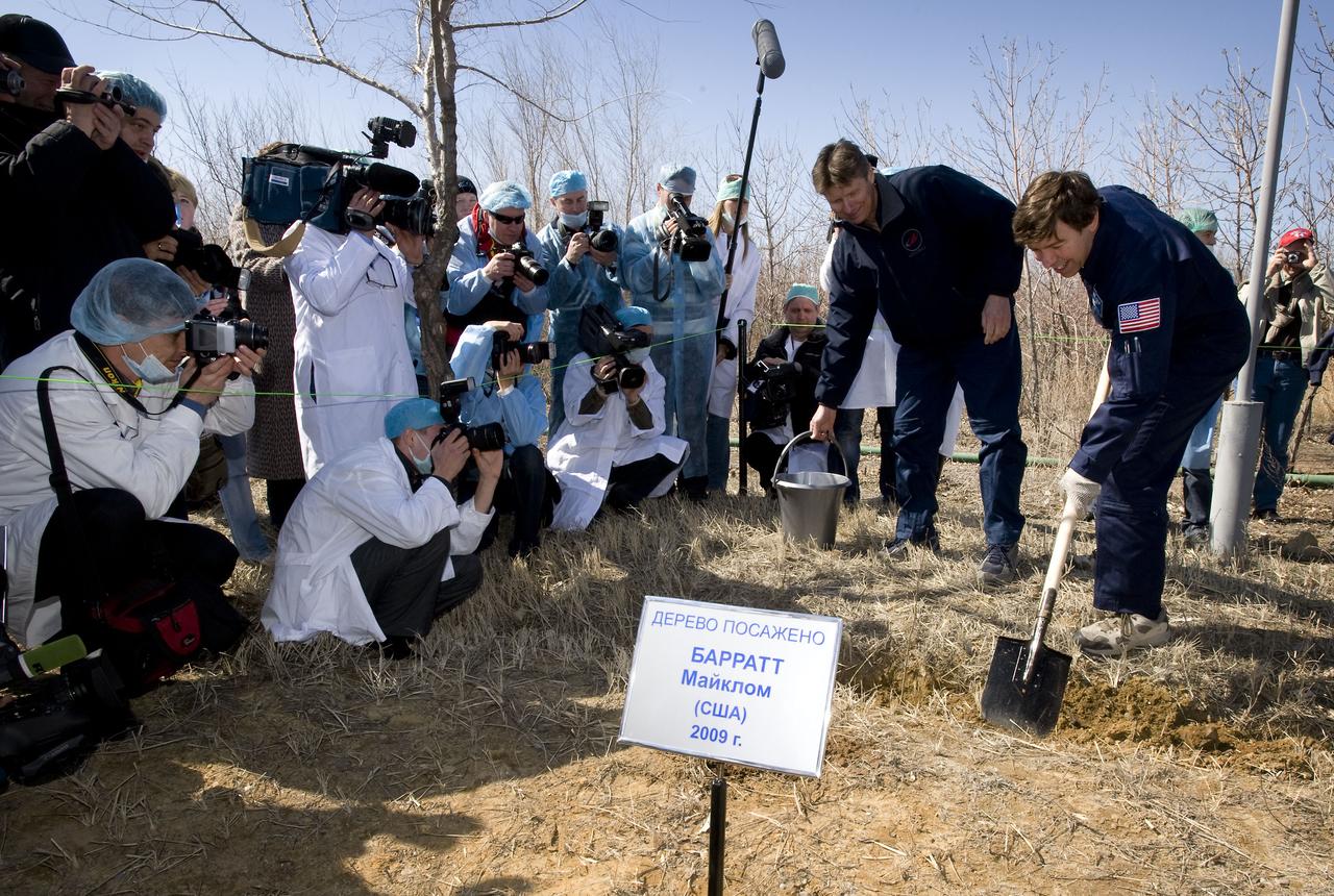 Members of the media watch as Expedition 19 Commander Gennady I. Padalka, left, and Flight Engineer Michael R. Barratt plant a tree during the traditional tree planting ceremony at the Cosmonaut Hotel, Saturday, March 21, 2009 in Baikonur, Kazakhstan.  (Photo Credit: NASA/Bill Ingalls)