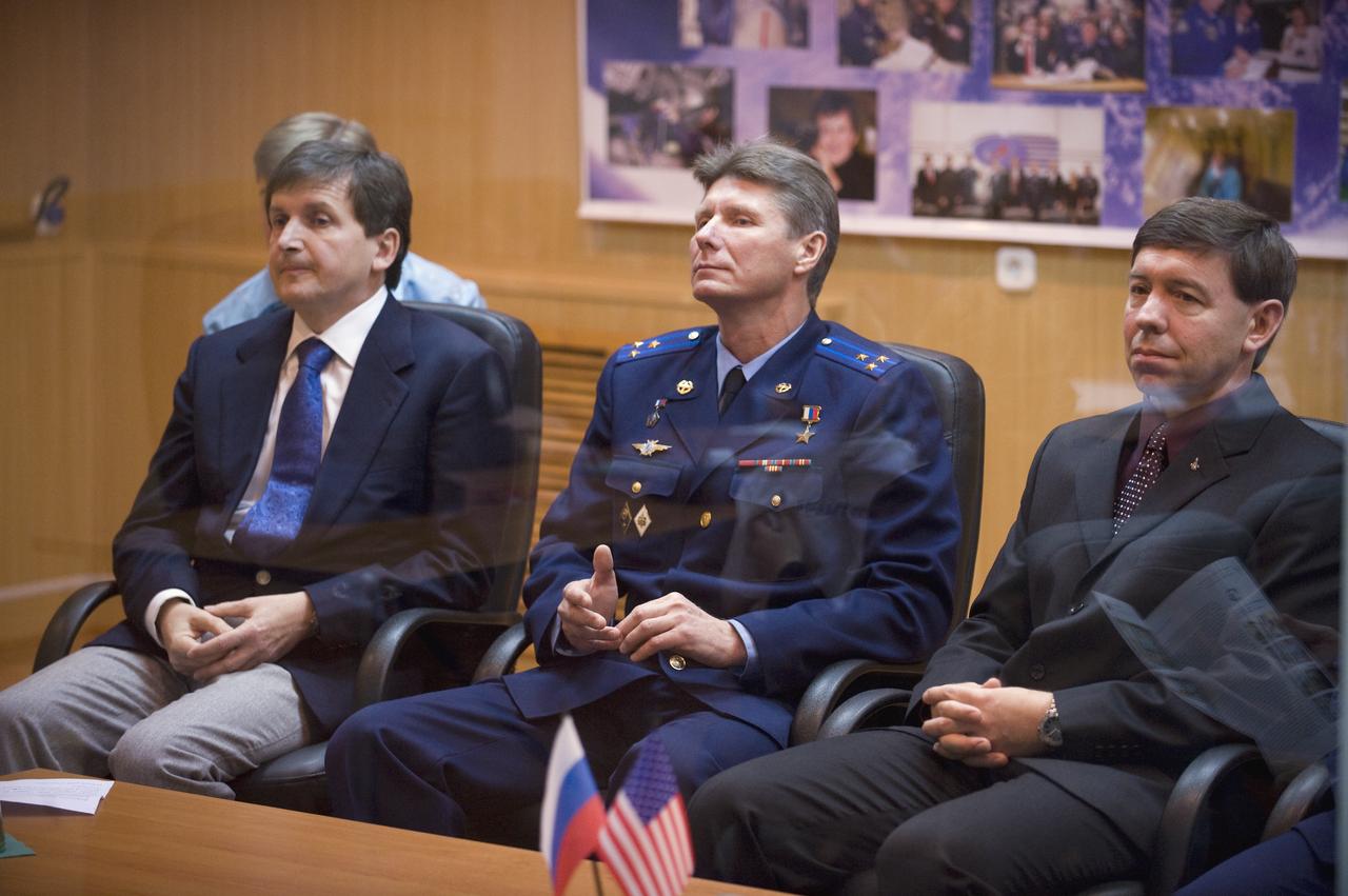 Spaceflight Participant Charles Simonyi, left, Expedition 19 Commander Gennady I. Padalka, center, and Flight Engineer Michael R. Barratt are seen in quarantine behind glass during the State Commission meeting on Wednesday, March 25, 2009 in Baikonur, Kazakhstan.  Photo Credit: (NASA/Bill Ingalls)