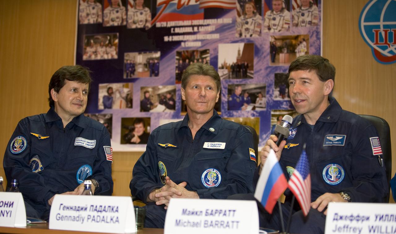 Spaceflight Participant Charles Simonyi, left, Expedition 19 Commander Gennady I. Padalka, center, and Flight Engineer Michael R. Barratt answer questions from behind glass during a press conference on Wednesday, March 25, 2009 at the Cosmonaut Hotel in Baikonur, Kazakhstan.  Photo Credit: (NASA/Bill Ingalls)
