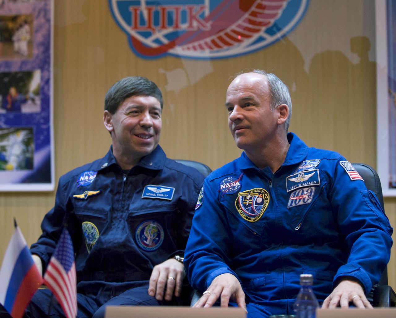 Expedition 19 Flight Engineer Michael R. Barratt, left, and backup commander Jeffrey Williams are seen in quarantine behind glass during a press conference on Wednesday, March 25, 2009 at the Cosmonaut Hotel in Baikonur, Kazakhstan.  Photo Credit: (NASA/Bill Ingalls)