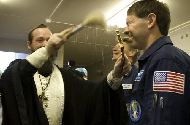 Expedition 19 Flight Engineer Michael R. Barratt receives the traditional blessing at the Cosmonaut Hotel on the morning of his Soyuz launch with Expedition 19 Commander Gennady I. Padalka and Spaceflight Participant Charles Simonyi to the International Space Station on Thursday, March 26, 2009 in Baikonur, Kazakhstan. (Photo Credit: NASA/Bill Ingalls)