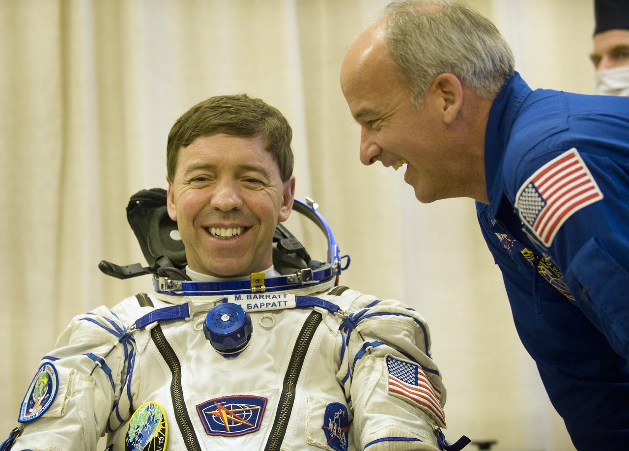 Expedition 19 Flight Engineer Michael R. Barratt, left, laughs with backup commander Jeffrey Williams in the suit up room of building 254, Thursday, March 26, 2009 in Baikonur, Kazakhstan. (Photo Credit: NASA/Bill Ingalls)
