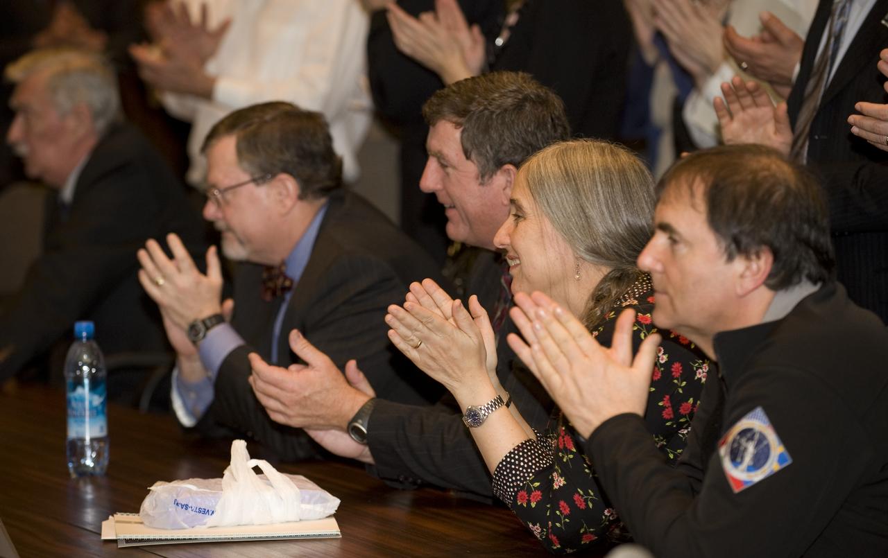 Michelle Barratt, 3rd from left, claps as she watches her husband, NASA Astronaut Mike Barratt, enter the International Space Station live on TV from the Russia Mission Control Center in Korolev, Russia, Saturday, March 28, 2009. The Soyuz TMA-14 docked to the International Space Station carrying Expedition 19 Commander Gennady I. Padalka, Flight Engineer Michael R. Barratt and Spaceflight Participant Charles Simonyi. Photo Credit: (NASA/Bill Ingalls)