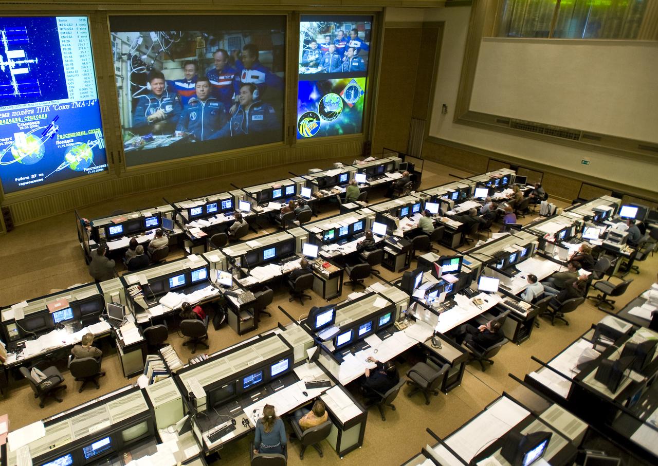 The crews of Expedition 18 and 19 are seen on a large TV screen in the Russian Mission Control Center in Korolev, Russia, Saturday, March 28, 2009 shortly after the Soyuz TMA-14 spacecraft docked to the International Space Station and delivered Expedition 19 Commander Gennady I. Padalka, Flight Engineer Michael R. Barratt and Spaceflight Participant Charles Simonyi. Photo Credit: (NASA/Bill Ingalls)