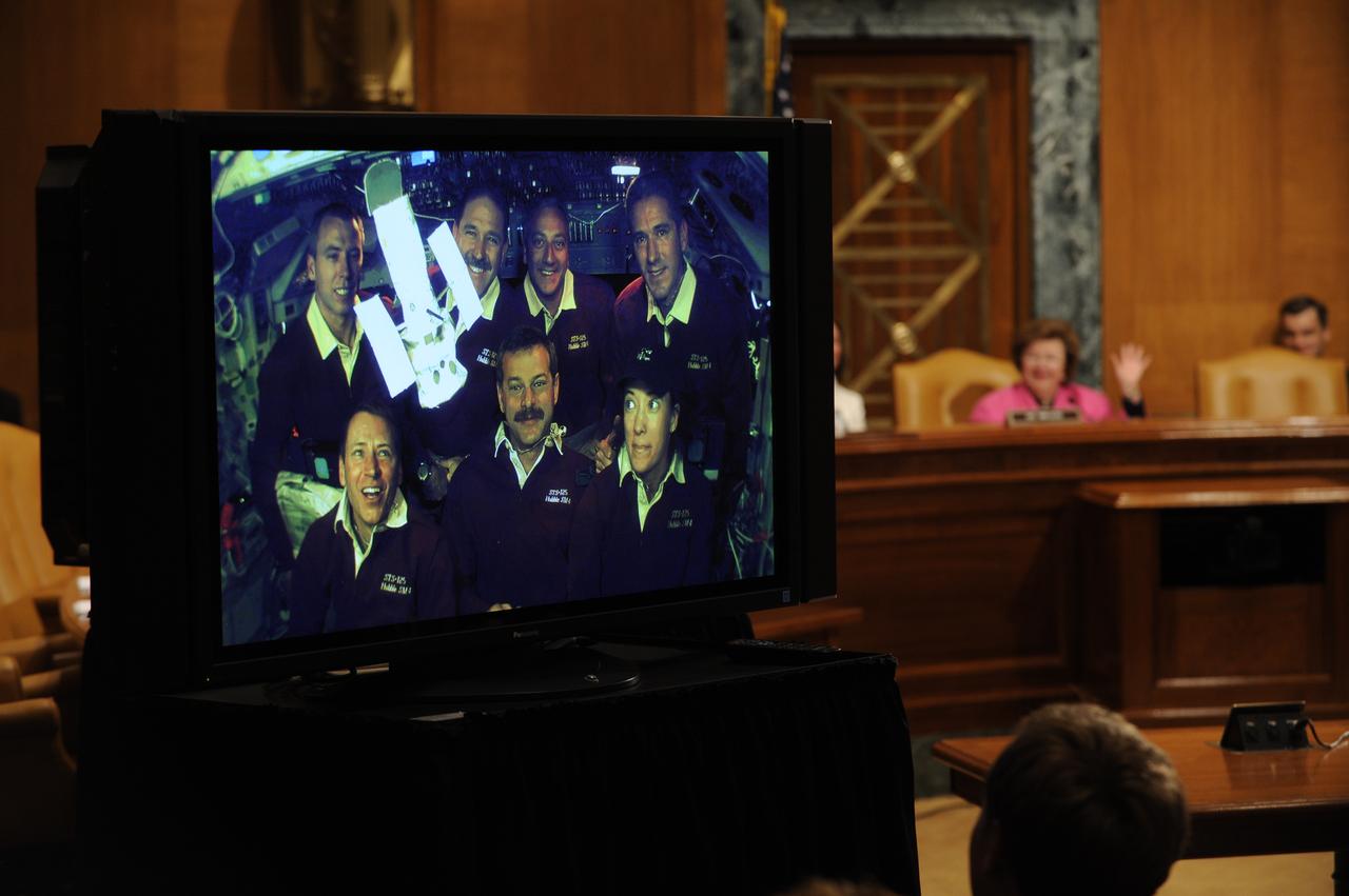 U.S. Sen. Barbara Mikulski, D-Md., rear right, waves to the crew of STS-125, at the end of a televised phone call to the space shuttle, Thursday, May 21, 2009, in a Dirksen Senate office building hearing room on Capitol Hill in Washington. The crew of STS-125 is returning to earth after finishing repairs on the Hubble Space Telescope. Photo Credit: (NASA/Paul E. Alers)