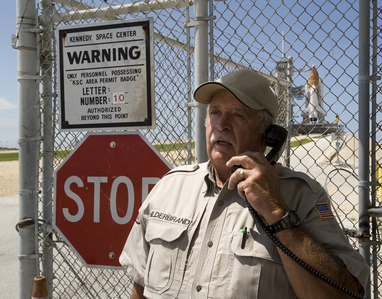 NASA Kennedy Space Center Security Officer, Jack "Supr Jac" Hilderbrand talks on the phone at the security gate to Pad 39a just a day shy of his 70th birthday and the planned launch of the space shuttle Endeavour with the STS-127 crew. Hilderbrand has been working for the space program since 1960. Photo Credit: (NASA/Bill Ingalls)