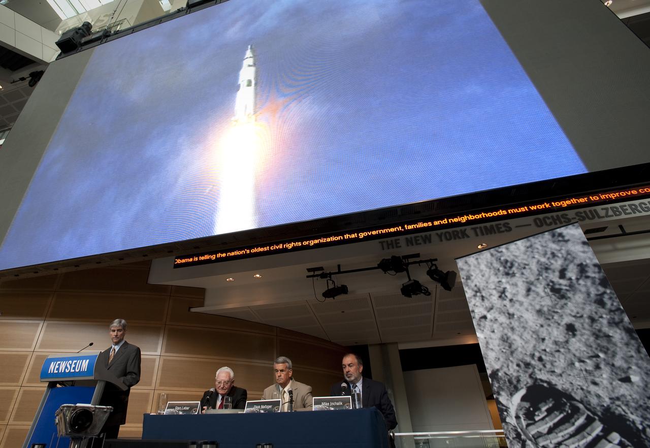 Footage of the Saturn V Apollo 11 rocket launch is seen on a large video monitor above panelists at NASA's briefing where restored Apollo 11 moonwalk footage was revealed for the first time at the Newseum, Thursday, July 16, 2009, in Washington, DC. Photo Credit: (NASA/Bill Ingalls)