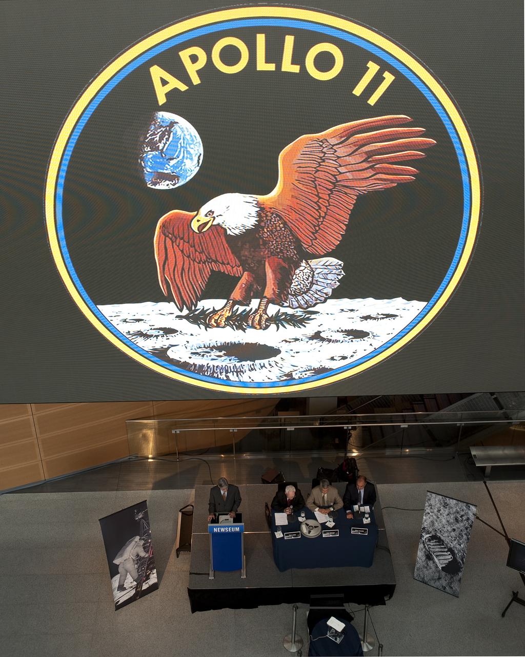 The Apollo 11 logo is seen on a large video monitor above panelists at NASA's briefing where restored Apollo 11 moonwalk footage was revealed for the first time at the Newseum, Thursday, July 16, 2009, in Washington, DC. Photo Credit: (NASA/Carla Cioffi)