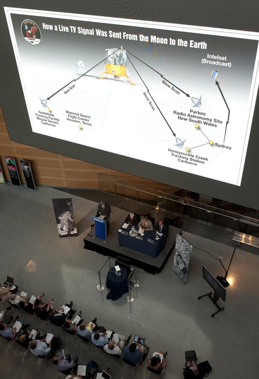 Graphics showing how TV signals were sent from the Apollo 11 mission back to Earth are shown on a large video monitor above panelists at NASA's briefing where restored Apollo 11 moonwalk footage was revealed for the first time at the Newseum, Thursday, July 16, 2009, in Washington, DC.  Photo Credit: (NASA/Carla Cioffi)