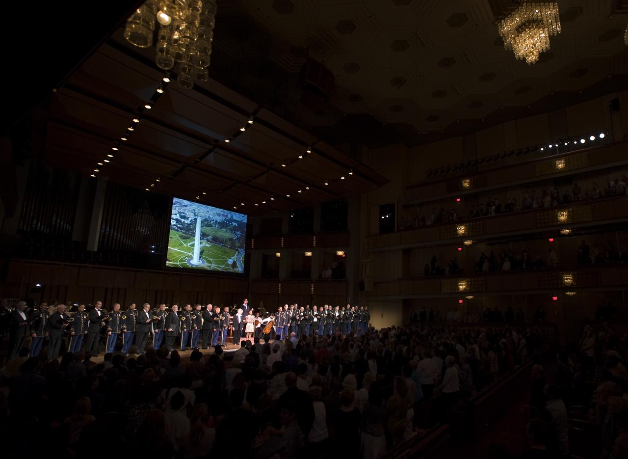 Emil de Cou conducts the National Symphony Orchestra, while singer Jamia Nash, actress June Lockhart, the U.S. Army Chorus and Alumni sing during the "Salute to Apollo" ceremony at the Kennedy Center for the Performing Arts, Saturday, July 18, 2009 in Washington.  The event was part of NASA's week long celebration of the Apollo 40th Anniversary.  Photo Credit: (NASA/Bill Ingalls)