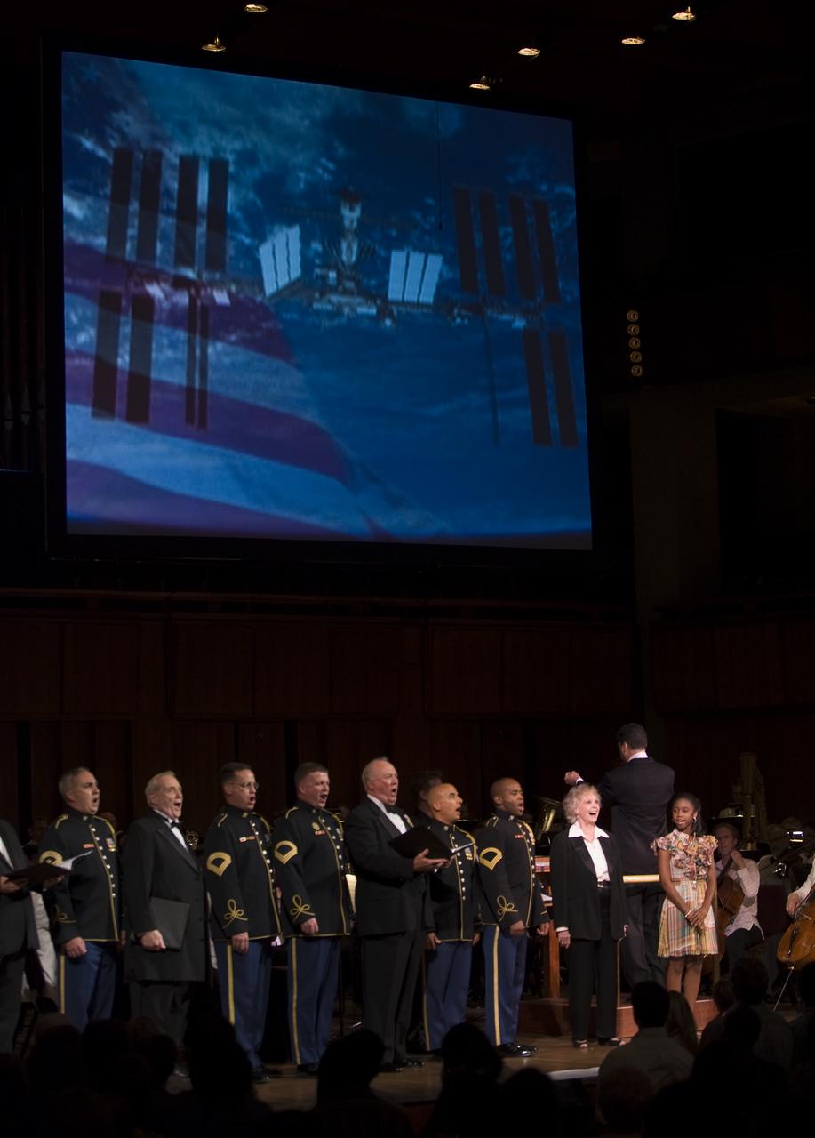 Emil de Cou conducts the National Symphony Orchestra, while singer Jamia Nash, actress June Lockhart, the U.S. Army Chorus and Alumni sing during the "Salute to Apollo" ceremony at the Kennedy Center for the Performing Arts, Saturday, July 18, 2009 in Washington.  The event was part of NASA's week long celebration of the Apollo 40th Anniversary.  Photo Credit: (NASA/Bill Ingalls)