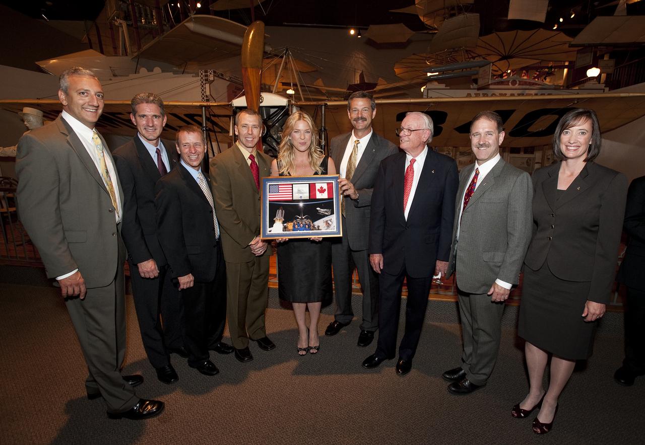 Jazz pianist and singer Diana Krall holds a montage given to her by the STS-125 space shuttle crew along with Apollo 11 Astronaut Neil Armstrong at the Apollo 40th anniversary celebration held at the National Air and Space Museum, Monday, July 20, 2009 in Washington. From left, Michael J. Massimino, Michael T. Good, Gregory C. Johnson, Andrew J. Feustel, Krall, Scott D. Altman, Neil Armstrong, John M. Grunsfeld and Megan McArthur. Photo Credit: (NASA/Bill Ingalls)