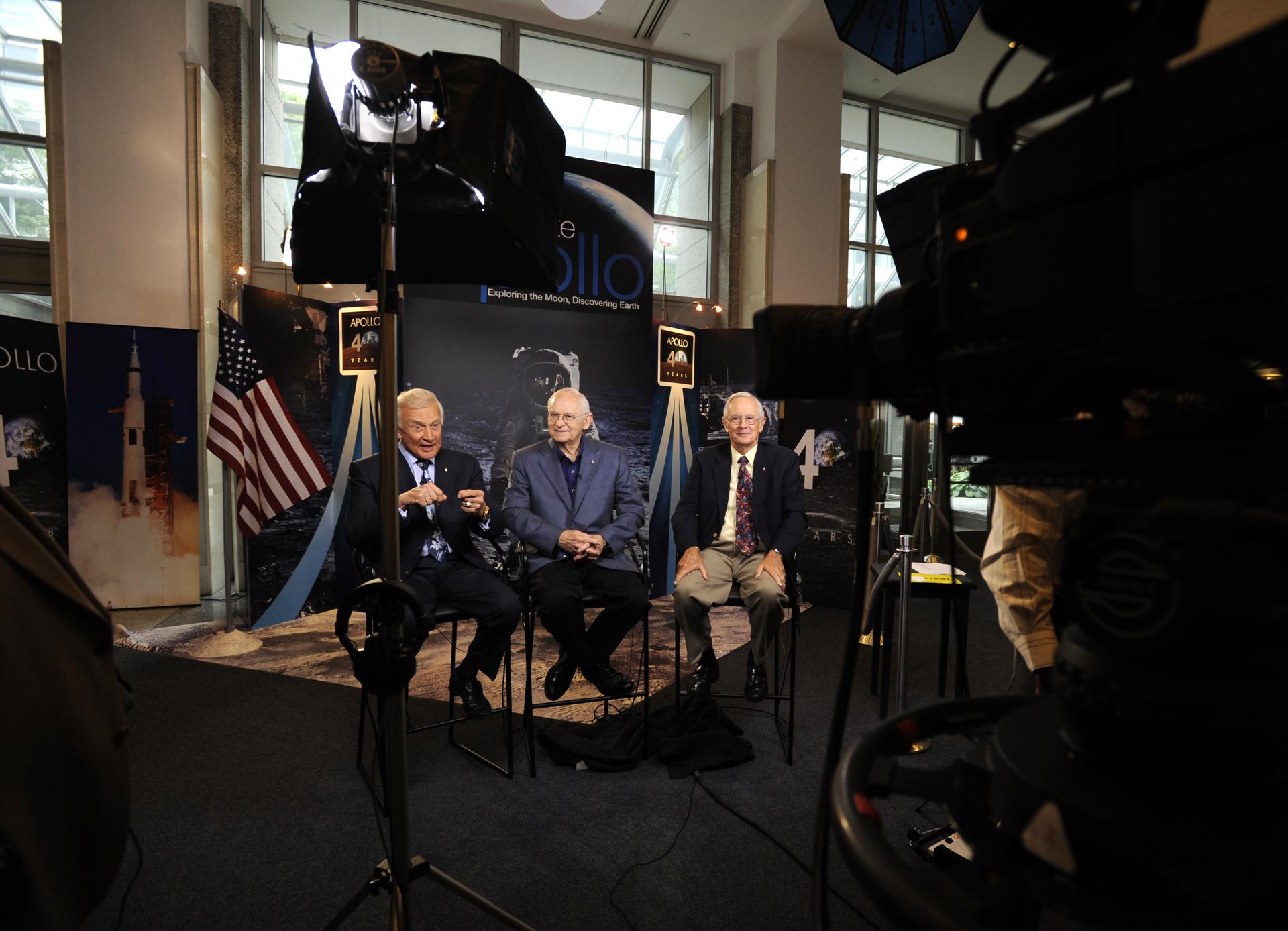 Apollo 11 astronaut Buzz Aldrin, the second man to walk on the Moon, seated left, responds to a question during a live television interview on Monday, July 20, 2009, at NASA Headquarters in Washington as Apollo 12 astronaut Alan Bean and Apollo 16 astronaut Charles Duke, right look on. The three sat in for interviews with morning talks shows covering the 40th Anniversary of the Apollo 11 landing on the Moon. Photo Credit: (NASA/Paul E. Alers)