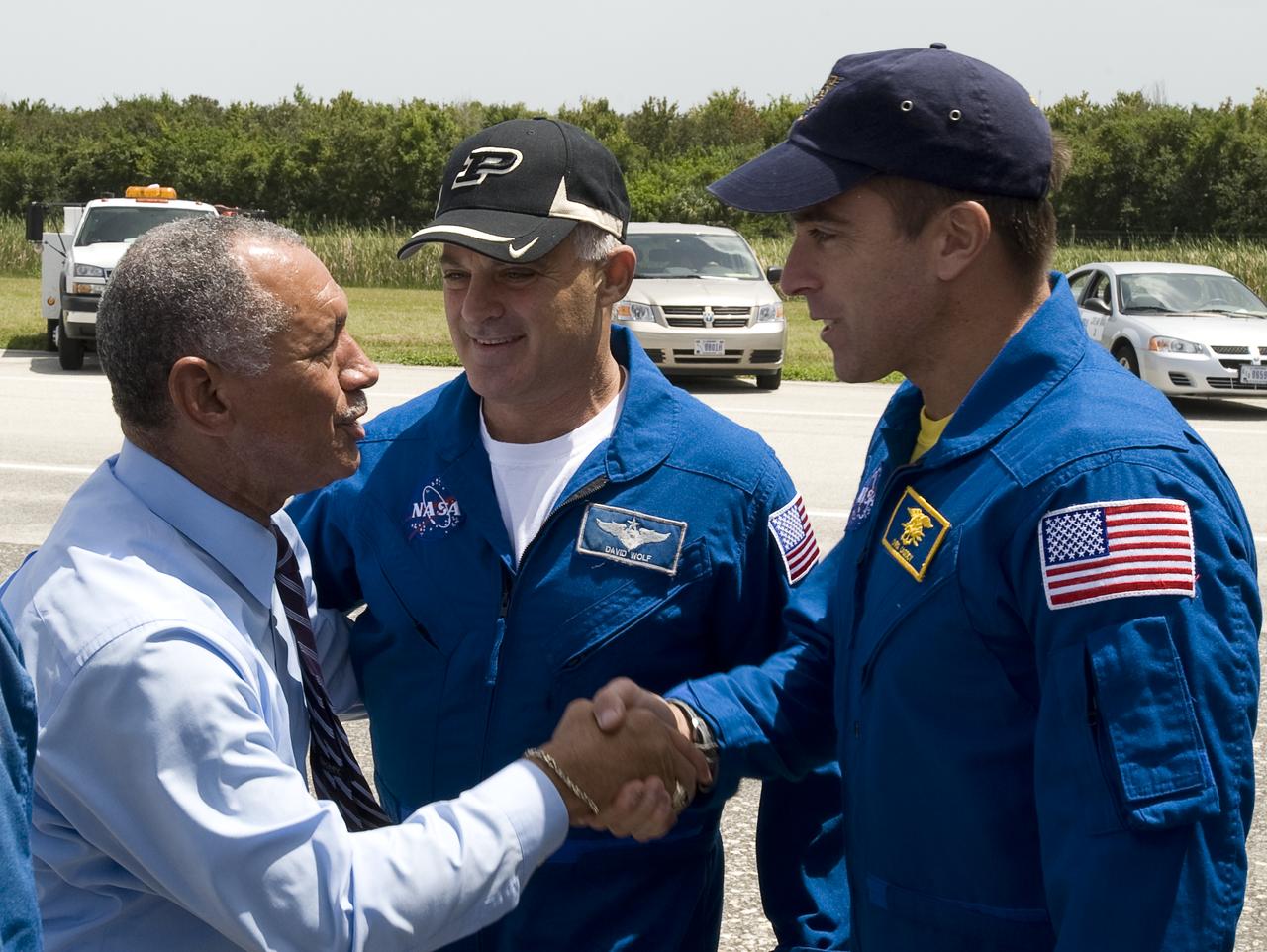 NASA Administrator Charles Bolden, left, welcomes home STS-127 Astronauts Dave Wolf, and Christopher Cassidy, right, shortly after the space shuttle Endeavour and its crew landed, Friday, July 31, 2009 at NASA's Kennedy Space Center in Cape Canaveral, Fla., completing a 16-day journey of more than 6.5 million miles. Endeavour delivered the final segment to the Japan Aerospace Exploration Agency's Kibo laboratory and a new crew member to the International Space Station.