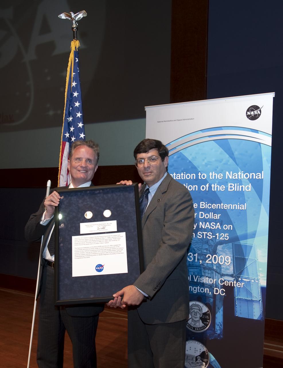 Dr. Marc Mauer, president of the National Federation of the Blind, left, accepts two Louis Braille Bicentennial Silver Dollars that flew on Space Shuttle Atlantis' mission (STS-125) to the Hubble Space Telescope in May 2009 from NASA Associate Administrator Chris Scolese, Friday evening, July 31, 2009, at the Capitol Visitors Center in Washington. Photo Credit: (NASA/Paul E. Alers)