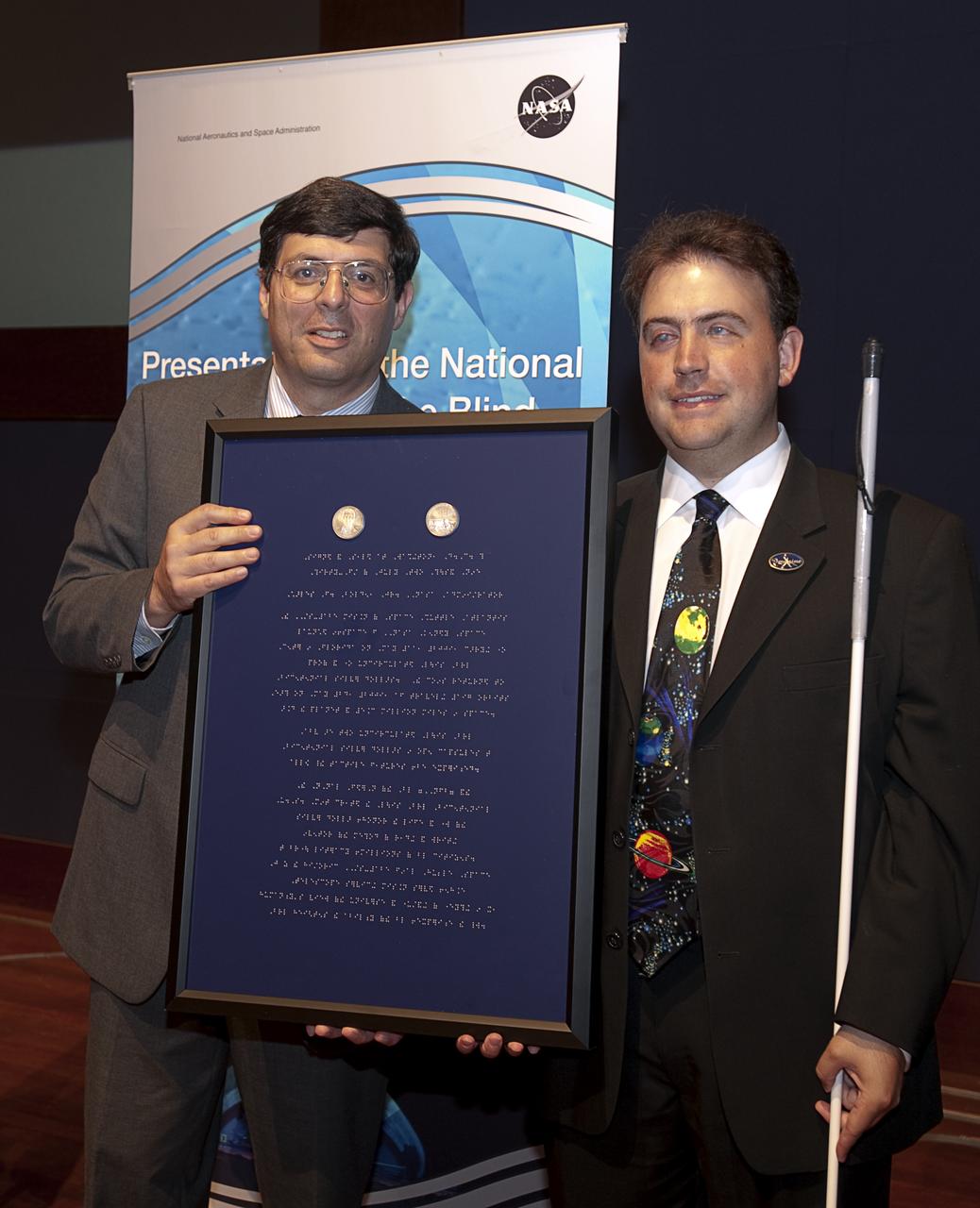 NASA Associate Administrator Chris Scolese, left, and Mark Riccobono, executive director of the Jernigan Institute of the National Federation of the Blind hold up a Braille enscribed award with two Louis Braille Bicentennial Silver Dollars at a ceremony where senior NASA officials presented the NFB with coins that flew on Space Shuttle Atlantis' mission (STS-125) to the Hubble Space Telescope in May 2009, Friday evening, July 31, 2009, at the Capitol Visitors Center in Washington. Photo Credit: (NASA/Paul E. Alers)