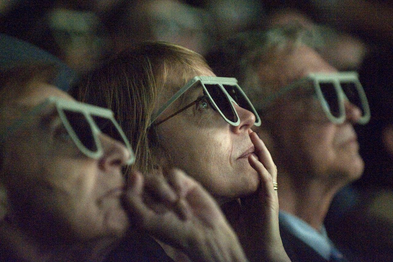 Unidentified people observe newly released images from the Hubble Space Telescope through special glasses Wednesday evening, Sept. 9, 2009, during a celebration of the Hubble Legacy at the National Air and Space Museum in Washington. Astronomers declared the telescope a fully rejuvenated observatory with the release Wednesday of observations from four of its six operating science instruments. Photo Credit: (NASA/Bill Ingalls)