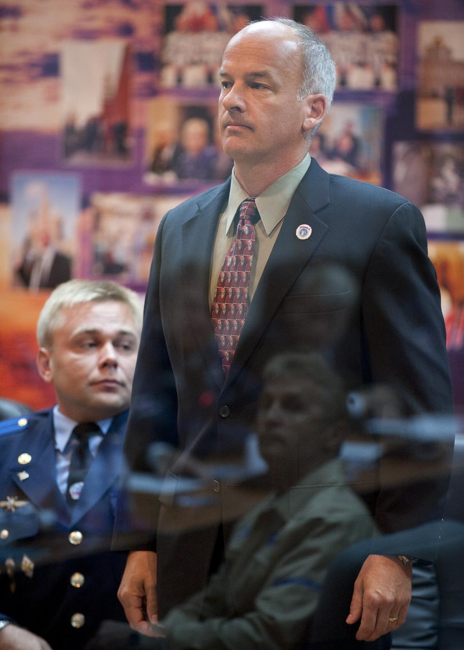Expedition 21 Flight Engineer Jeffrey N. Williams stands as he is recognized during the State Commission meeting to approve the Soyuz launch of Williams, Expedition 21 Flight Engineer Maxim Suraev, and Spaceflight Participant Guy Laliberté on Tuesday, Sept. 29, 2009 in Baikonur, Kazakhstan. The crew is kept in a separate room with a glass window in order to help maintain their health. Photo Credit: (NASA/Bill Ingalls)