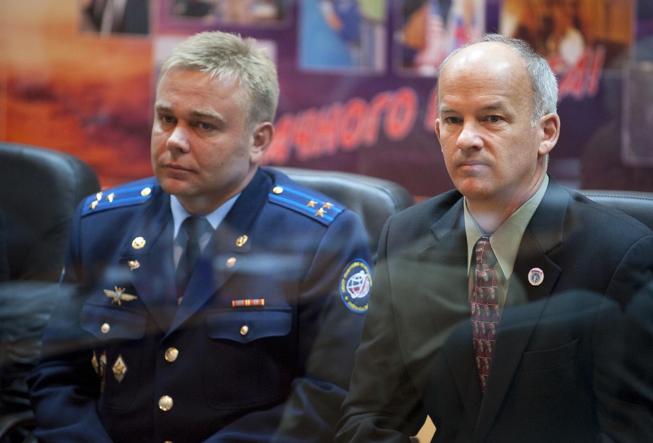 Expedition 21 Flight Engineer Maxim Suraev, left, and Expedition 21 Flight Engineer Jeffrey N. Williams are seen during the State Commission meeting to approve the Soyuz launch of Williams, Suraev, and Spaceflight Participant Guy Laliberté on Tuesday, Sept. 29, 2009 in Baikonur, Kazakhstan. The crew is kept in a separate room with a glass window in order to help maintain their health. Photo Credit: (NASA/Bill Ingalls)
