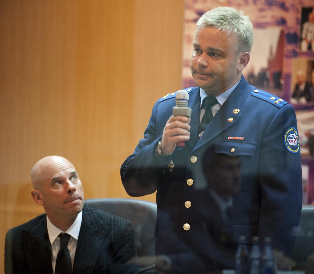 Spaceflight Participant Guy Laliberté, left, listens as Expedition 21 Flight Engineer Maxim Suraev speaks during the State Commission meeting to approve the Soyuz launch of Expedition 21 Flight Engineer Jeffrey N. Williams, Expedition 21 Flight Engineer Maxim Suraev, and Spaceflight Participant Guy Laliberté on Tuesday, Sept. 29, 2009 in Baikonur, Kazakhstan. The crew is kept in a separate room with a glass window in order to help maintain their health. Photo Credit: (NASA/Bill Ingalls)