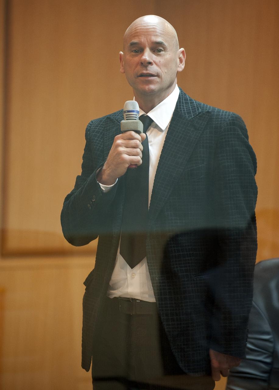 Spaceflight Participant Guy Laliberté, speaks during the State Commission meeting to approve the Soyuz launch of Expedition 21 Flight Engineer Jeffrey N. Williams, Expedition 21 Flight Engineer Maxim Suraev, and Laliberté on Tuesday, Sept. 29, 2009 in Baikonur, Kazakhstan. The crew is kept in a separate room with a glass window in order to help maintain their health. Photo Credit: (NASA/Bill Ingalls)