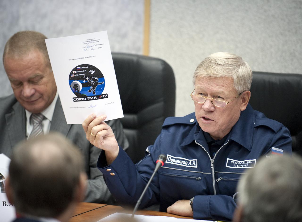 Head of the Russian Federal Space Agency, Anatoly Perminov shows a logo that will be used for the Expedition 22 mission during the State Commission meeting to approve the Soyuz launch of Expedition 21 Flight Engineer Jeffrey N. Williams, Expedition 21 Flight Engineer Maxim Suraev, and Spaceflight Participant Guy Laliberté on Tuesday, Sept. 29, 2009 in Baikonur, Kazakhstan. The logo incorporates designs from a children's competition.  Photo Credit: (NASA/Bill Ingalls)