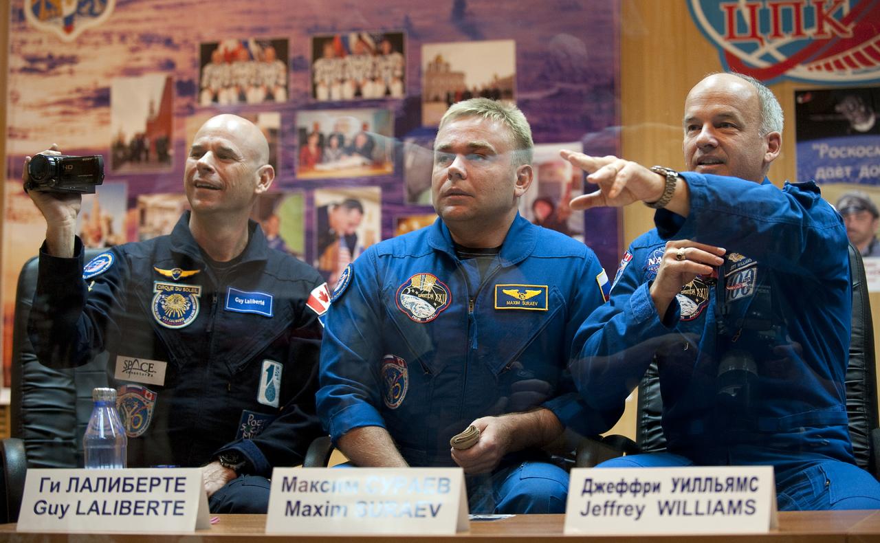 Spaceflight Participant Guy Laliberté, left, Expedition 21 Flight Engineer Maxim Suraev, center, and Expedition 21 Flight Engineer Jeffrey N. Williams wave hello and point to members of their families at the start of the press conference, Tuesday, Sept. 29, 2009 at the Cosmonaut Hotel in Baikonur, Kazakhstan. Photo Credit: (NASA/Bill Ingalls)