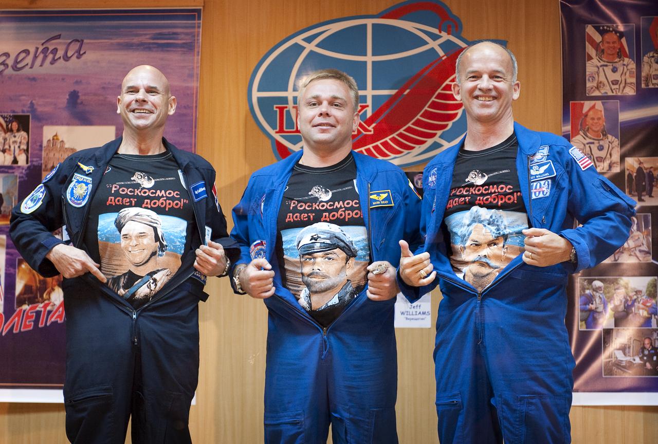 Spaceflight Participant Guy Laliberté, left, Expedition 21 Flight Engineer Maxim Suraev, center, and Expedition 21 Flight Engineer Jeffrey N. Williams reveal t-shirts showing their faces superimposed on characters from the Russian movie "White Sun of the Desert" at the end of the press conference, Tuesday, Sept. 29, 2009 at the Cosmonaut Hotel in Baikonur, Kazakhstan. It is tradition for all crews flying on the Soyuz to watch this movie several days before they launch. Photo Credit: (NASA/Bill Ingalls)