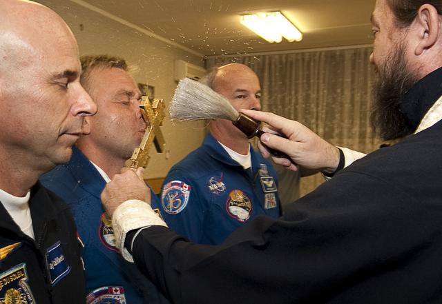 Spaceflight Participant Guy Laliberté, left, Expedition 21 Flight Engineer Maxim Suraev, left center, and Expedition 21 Flight Engineer Jeffrey N. Williams receive the traditional blessing from a Russian Orthodox priest at the Cosmonaut Hotel on the morning of their Soyuz launch to the International Space Station on Wednesday, Sept. 30, 2009 in Baikonur, Kazakhstan. Photo Credit: (NASA/Bill Ingalls)
