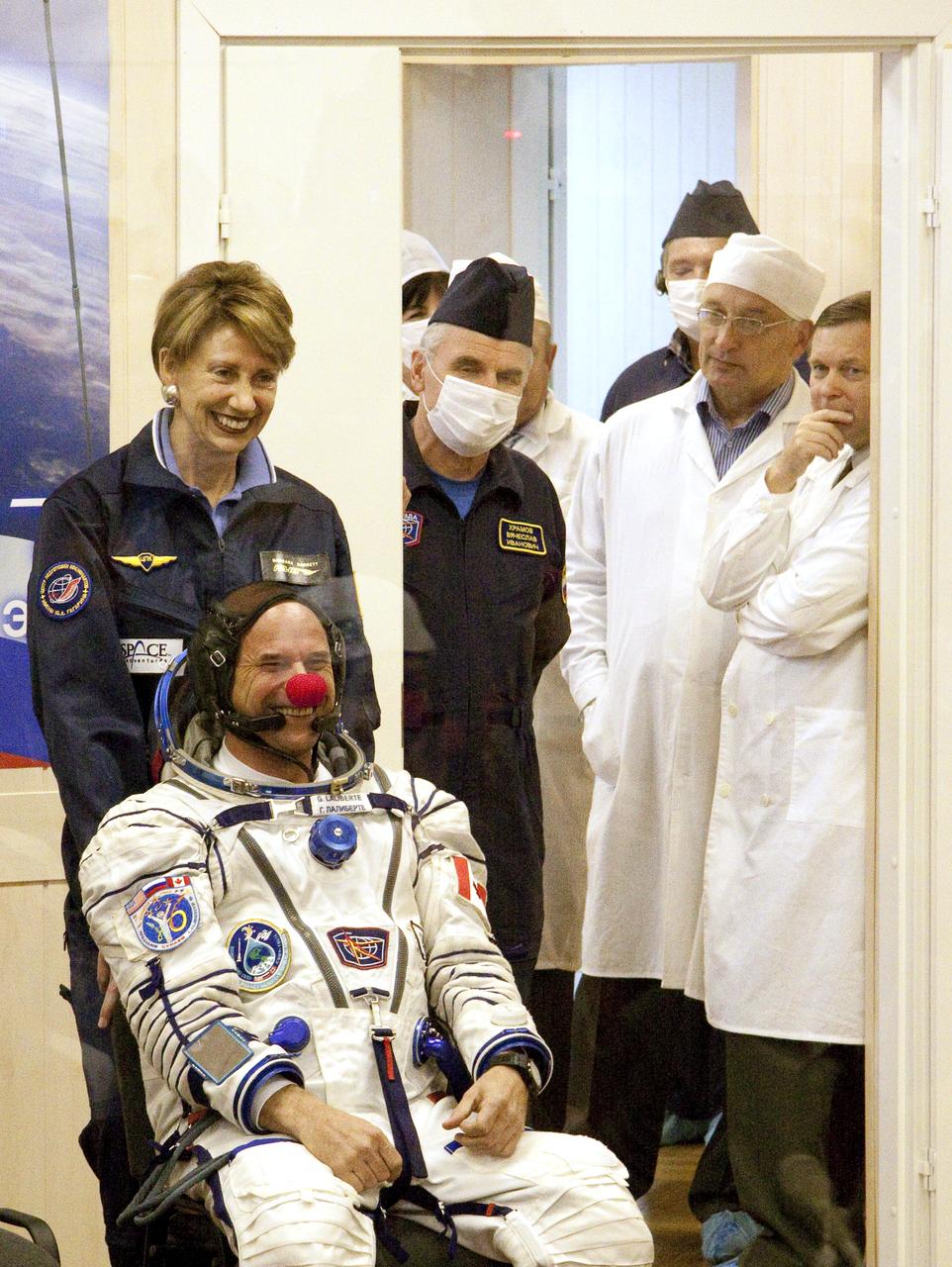 Spaceflight Participant Guy Laliberté, smiles with his red clown nose on from behind glass as he waits for his turn to have his Russian Sokol suit pressure tested prior to his launch to the International Space Station (ISS) with Expedition 21 Flight Engineer Maxim Suraev and Expedition 21 Flight Engineer Jeffrey N. Williams, Wednesday, Sept. 30, 2009 in Baikonur, Kazakhstan. Photo Credit: (NASA/Victor Zelentsov)