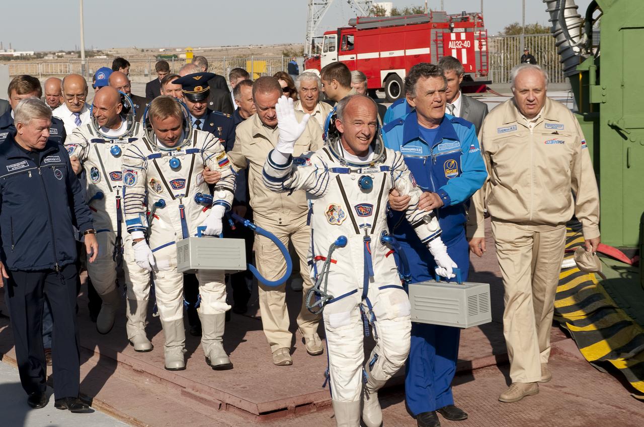 Spaceflight Participant Guy Laliberté, left, Expedition 21 Flight Engineer Maxim Suraev, center and Expedition 21 Flight Engineer Jeffrey N. Williams walk to the Soyuz rocket and wave farewell prior to their launch to the International Space Station (ISS), Wednesday, Sept. 30, 2009 in Baikonur, Kazakhstan. Photo Credit: (NASA/Bill Ingalls)