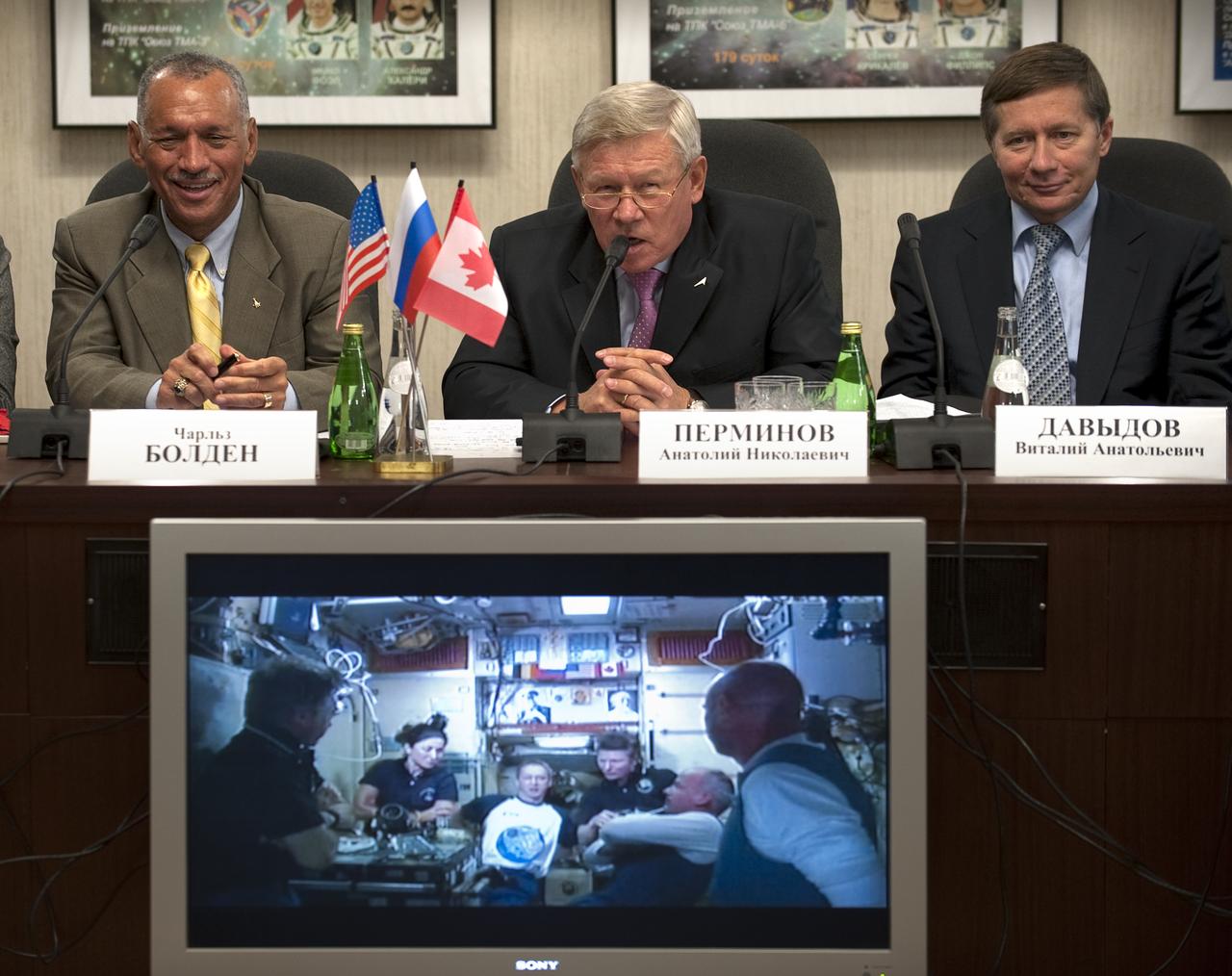 NASA Administrator Charles Bolden, left, Head of the Russian Federal Space Agency, Anatoly Perminov, center, and Deputy Head of the Russian Federal Space Agency, Vitaly A. Davyidov listen to reporters questions during a press conference at Mission Control Center Moscow in Korolev, Russia shortly after the successful docking of the Soyuz TMA-16 spacecraft with the International Space Station (ISS) marking the start of Expedition 21 with Flight Engineer Jeffrey N. Williams, Expedition 21 Flight Engineer Maxim Suraev, and Spaceflight Participant Guy Laliberté, Friday, Oct. 2, 2009. The entire crew onboard the ISS can be seen in the monitor below. Photo Credit: (NASA/Bill Ingalls)