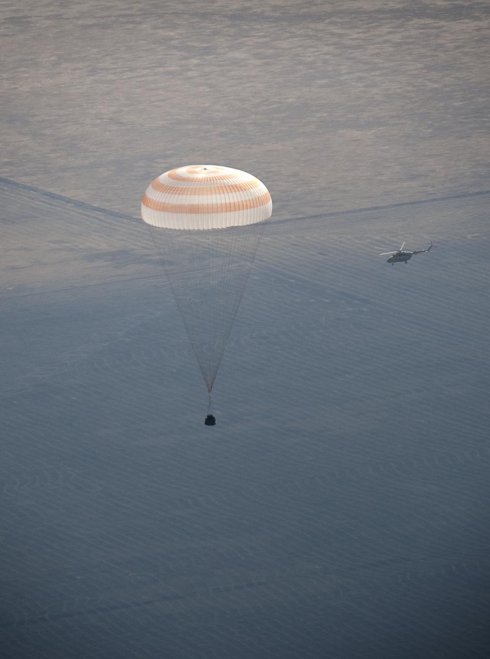 A Russian Search and Rescue force helicopter flies around the Soyuz TMA-14 spacecraft as it lands with Expedition 20 Commander Gennady Padalka, Flight Engineer Michael Barratt, and spaceflight participant Guy Laliberté near the town of Arkalyk, Kazakhstan on Sunday, Oct. 11, 2009. Padalka and Barratt are returning from six months onboard the International Space Station, along with Laliberté who arrived at the station on Oct. 2 with Expedition 21 Flight Engineers Jeff Williams and Maxim Suraev aboard the Soyuz TMA-16 spacecraft. Photo Credit: (NASA/Bill Ingalls)