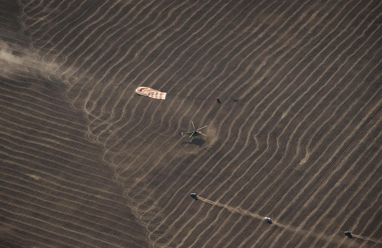 Russian Search and Rescue force vehicles and helicopter arrive within seconds of the Soyuz TMA-14 spacecraft landing with Expedition 20 Commander Gennady Padalka, Flight Engineer Michael Barratt, and spaceflight participant Guy Laliberté near the town of Arkalyk, Kazakhstan on Sunday, Oct. 11, 2009. Padalka and Barratt are returning from six months onboard the International Space Station, along with Laliberté who arrived at the station on Oct. 2 with Expedition 21 Flight Engineers Jeff Williams and Maxim Suraev aboard the Soyuz TMA-16 spacecraft. Photo Credit: (NASA/Bill Ingalls)