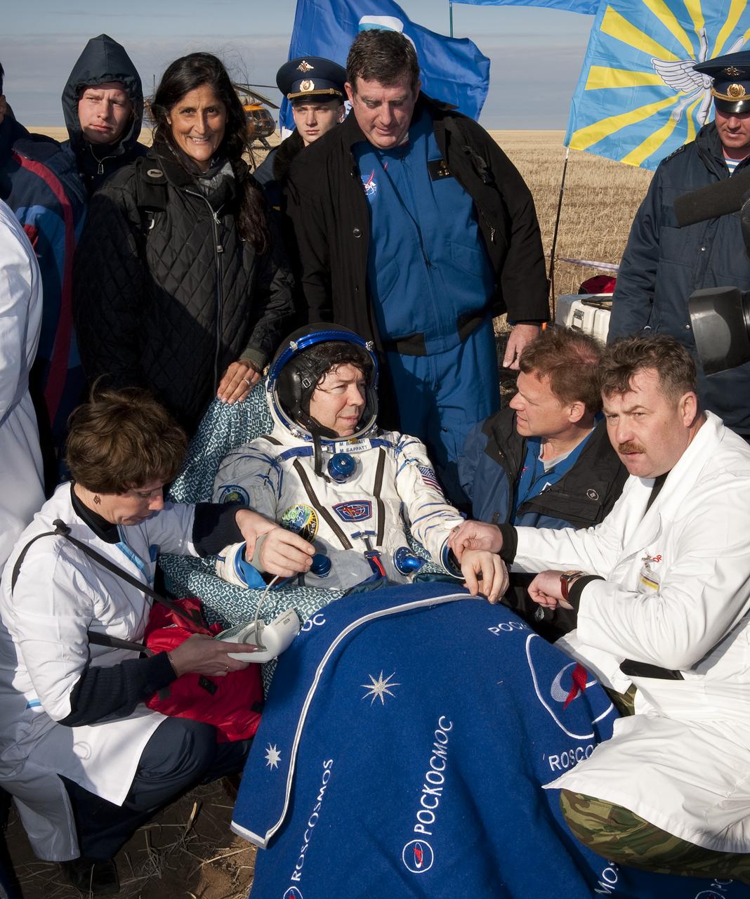 Expedition 20 Flight Engineer Michael Barratt rests in a chair and is checked by medical personnel shortly after he and Spaceflight participant Guy Lalibert√©, and Expedition 20 Commander Gennady Padalka landed in their Soyuz TMA-14 capsule near the town of Arkalyk, Kazakhstan on Sunday, Oct. 11, 2009. Padalka and Barratt are returning from six months onboard the International Space Station, along with Lalibert√© who arrived at the station on Oct. 2 with Expedition 21 Flight Engineers Jeff Williams and Maxim Suraev aboard the Soyuz TMA-16 spacecraft.  Photo Credit: (NASA/Bill Ingalls)