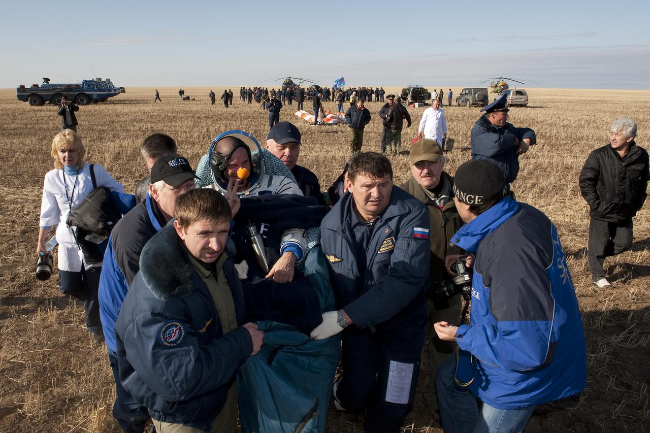 Spaceflight participant Guy Laliberté is carried in a chair to the medical tent shortly after he and Expedition 20 Flight Engineer Michael Barratt, and Expedition 20 Commander Gennady Padalka landed in their Soyuz TMA-14 capsule near the town of Arkalyk, Kazakhstan on Sunday, Oct. 11, 2009. Padalka and Barratt are returning from six months onboard the International Space Station, along with Laliberté who arrived at the station on Oct. 2 with Expedition 21 Flight Engineers Jeff Williams and Maxim Suraev aboard the Soyuz TMA-16 spacecraft. Photo Credit: (NASA/Bill Ingalls)