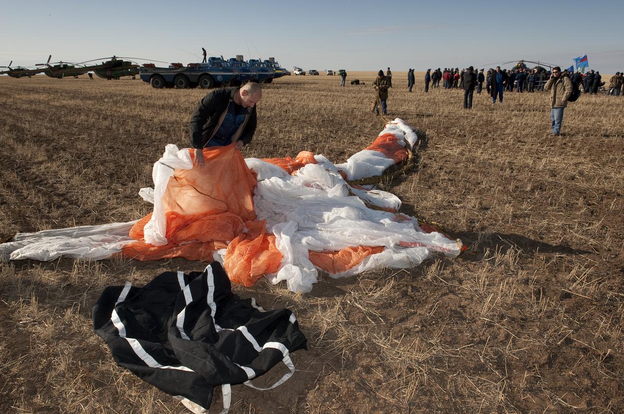 A member of the Russian Search and Rescue team folds up the parachute that was used to during the landing of the Soyuz TMA-14 spacecraft with Expedition 20 Commander Gennady Padalka, Flight Engineer Michael Barratt, and spaceflight participant Guy Laliberté near the town of Arkalyk, Kazakhstan on Sunday, Oct. 11, 2009. Padalka and Barratt are returning from six months onboard the International Space Station, along with Laliberté who arrived at the station on Oct. 2 with Expedition 21 Flight Engineers Jeff Williams and Maxim Suraev aboard the Soyuz TMA-16 spacecraft. Photo Credit: (NASA/Bill Ingalls)