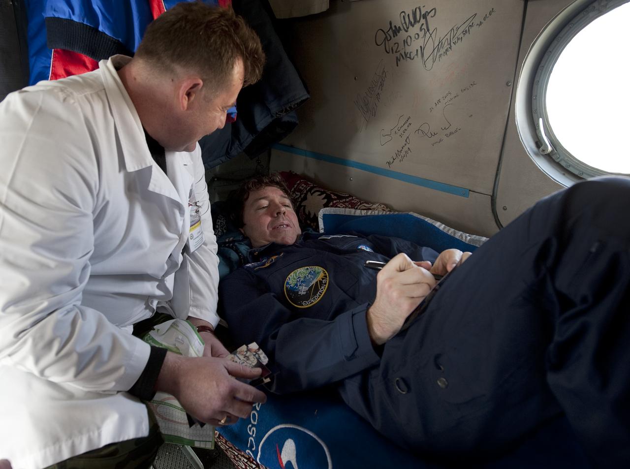 Expedition 20 Flight Engineer Michael Barratt signs an autograph inside a helicopter shortly after shortly after he and Expedition 20 Commander Gennady Padalka, and spaceflight participant Guy Laliberté landed their Soyuz TMA-14 capsule near the town of Arkalyk, Kazakhstan on Sunday, Oct. 11, 2009. Padalka and Barratt are returning from six months onboard the International Space Station, along with Laliberté who arrived at the station on Oct. 2 with Expedition 21 Flight Engineers Jeff Williams and Maxim Suraev aboard the Soyuz TMA-16 spacecraft.  Photo Credit: (NASA/Bill Ingalls)
