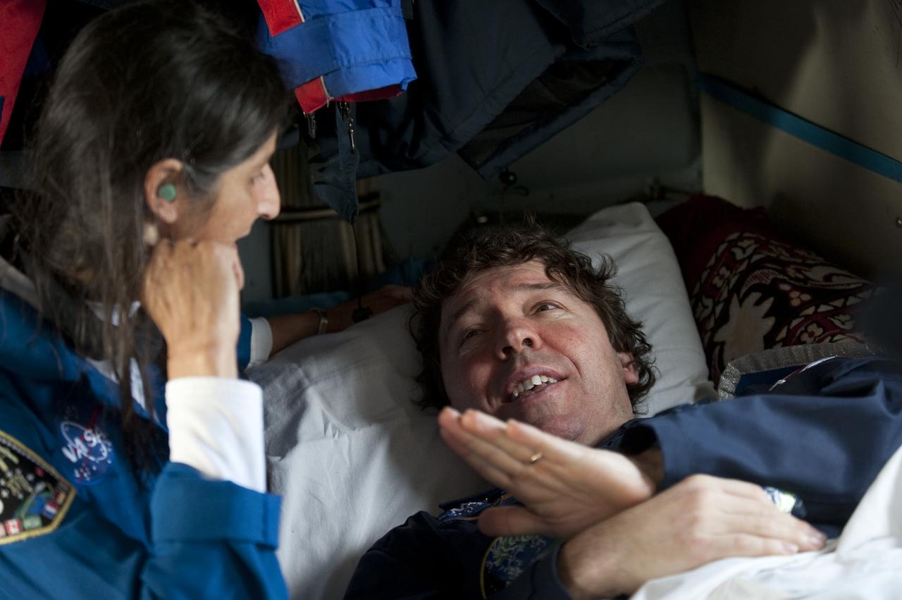 Astronaut Sunita WIlliams, left, talks with Expedition 20 Flight Engineer Michael Barratt onboard a helicopter shortly after shortly after he and Expedition 20 Commander Gennady Padalka, and spaceflight participant Guy Lalibert√© landed their Soyuz TMA-14 capsule near the town of Arkalyk, Kazakhstan on Sunday, Oct. 11, 2009. Padalka and Barratt are returning from six months onboard the International Space Station, along with Lalibert√© who arrived at the station on Oct. 2 with Expedition 21 Flight Engineers Jeff Williams and Maxim Suraev aboard the Soyuz TMA-16 spacecraft.  Photo Credit: (NASA/Bill Ingalls)