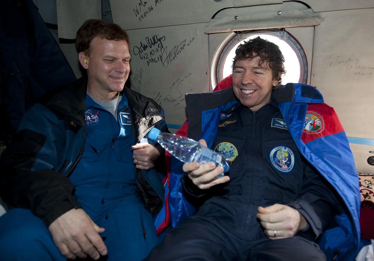NASA Flight Surgeon Ed Powers, left, laughs as Expedition 20 Flight Engineer Michael Barratt talks about how strange, weight and gravity feel when holding a bottle of water shortly after Barratt, Expedition 20 Commander Gennady Padalka, and spaceflight participant Guy Laliberté landed their Soyuz TMA-14 capsule near the town of Arkalyk, Kazakhstan on Sunday, Oct. 11, 2009. Padalka and Barratt are returning from six months onboard the International Space Station, along with Laliberté who arrived at the station on Oct. 2 with Expedition 21 Flight Engineers Jeff Williams and Maxim Suraev aboard the Soyuz TMA-16 spacecraft.  Photo Credit: (NASA/Bill Ingalls)