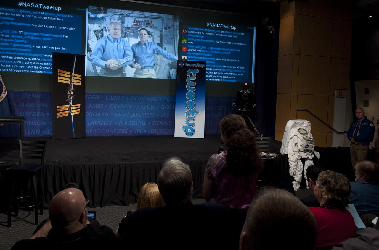 Expedition 20 Flight Engineers Jeff Williams, left, and Nicole Stott, seen on screen, are asked a question by a NASA Twitter follower, center, during a question and answer session at a live Tweetup event at NASA Headquarters in Washington, Wednesday, Oct. 21, 2009.  Photo Credit: (NASA/Carla Cioffi)