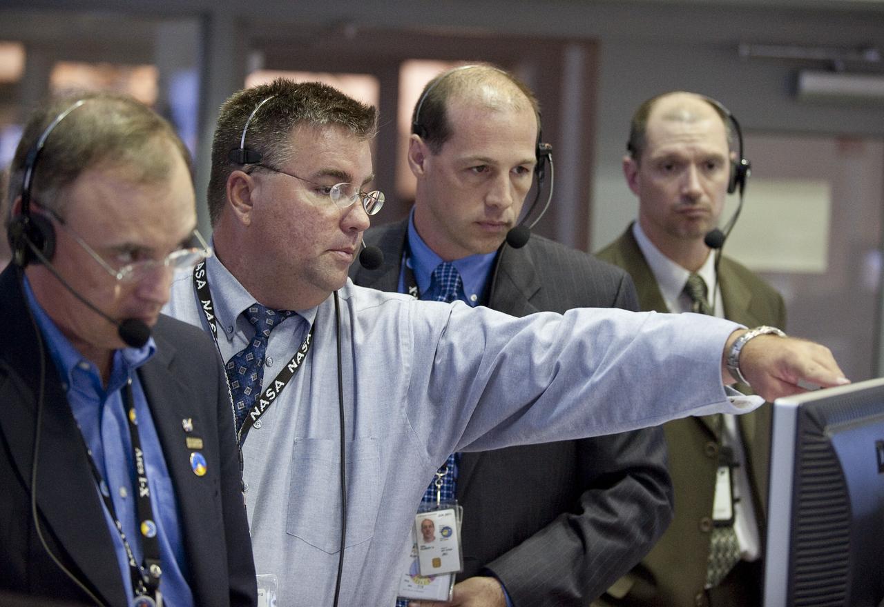 Mission managers, from left, NASA Constellation Program manager Jeff Hanley, Ares I-X Launch Director Ed Mango, Ares I-X mission manager Bob Ess, Ground Operations Manager Philip "Pepper" Phillips, review the latest data in Firing Room One of the Launch Control Center (LCC) at the Kennedy Space Center during the launch countdown of the Ares I-X rocket in Cape Canaveral, Fla., Tuesday, Oct. 27, 2009.  The flight test of Ares I-X will provide NASA with an early opportunity to test and prove flight characteristics, hardware, facilities and ground operations associated with the Ares I.  Photo Credit: (NASA/Bill Ingalls)