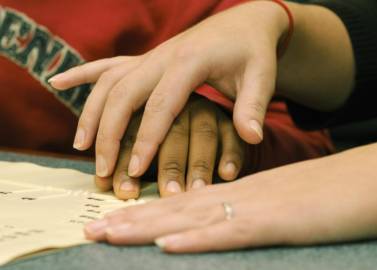 The hands of Maryland School for the Blind student Andrea Washington and science teacher Colleen Shovestull use their sense of touch on a topographical map of the solar system during a visit to NASA Headquarters in Washington, Thursday, Oct. 29, 2009.  Seven students from the Maryland School for the Blind visited NASA and participated in activities to learn about NASA'smission, functions, and careers. Photo Credit: (NASA/Paul E. Alers)