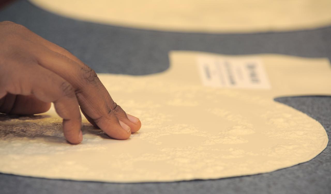 The fingers of a student from the Maryland School for the Blind touches on a topographical map to learn about the surface of the Moon during a visit to NASA Headquarters in Washington, Thursday, Oct. 29, 2009.  Seven students from the Maryland School for the Blind visited NASA and participated in activities to learn about NASA'smission, functions, and careers. Photo Credit: (NASA/Paul E. Alers)