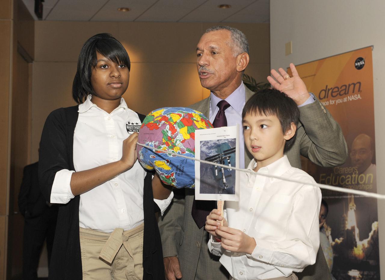 NASA Administrator Charles F. Bolden, center, stands with two unidentified students as he performs a demonstration to illustrate how far the International Space Station is from the Earth in comparison with the Moon, during an event where students spoke via downlink to astronauts on the ISS, Thursday, Nov. 5, 2009, at the U.S. Department of Education in Washington. Photo Credit: (NASA/Paul E. Alers)