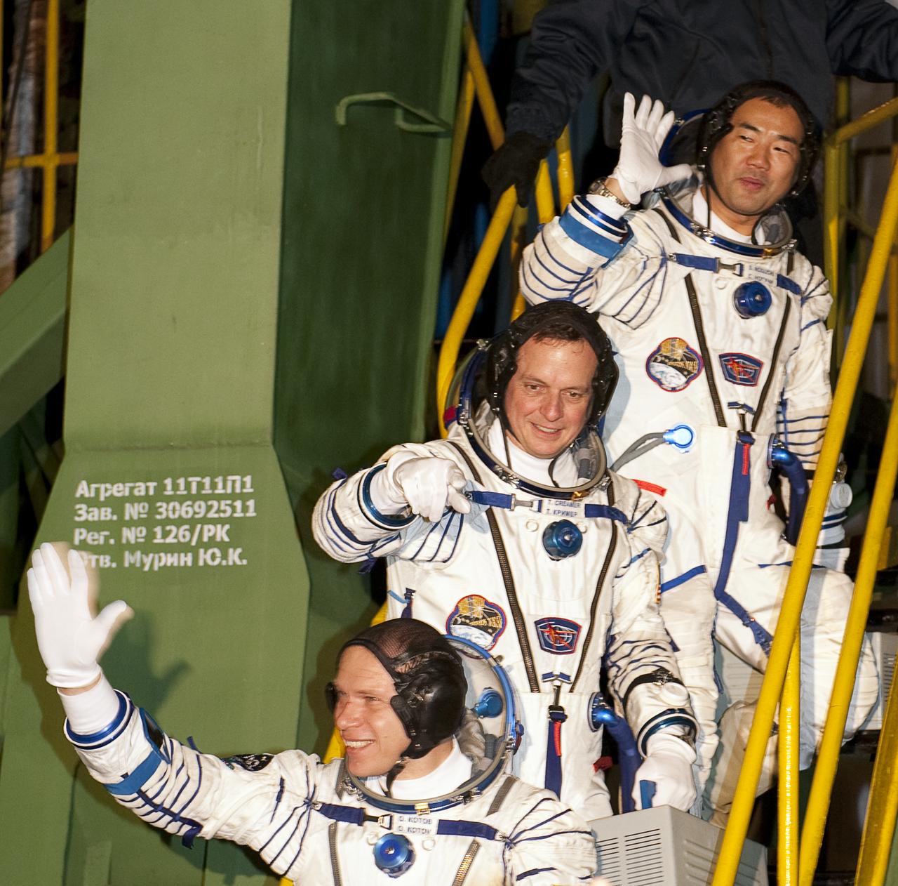 Expedition 22  Soyuz Commander Oleg Kotov of Russia, bottom, NASA Flight Engineer Timothy J. Creamer of the U.S., center, and Flight Engineer Soichi Noguchi of Japan wave farewell from the bottom of the soyuz rocket at the Baikonur Cosmodrome in Baikonur, Kazakhstan, Monday, Dec. 21, 2009. Kotov, Creamer and Noguchi launched in their Soyuz TMA-17 rocket from the Baikonur Cosmodrome in Kazakhstan on Monday, Dec. 21, 2009. (Photo Credit: NASA/Bill Ingalls)