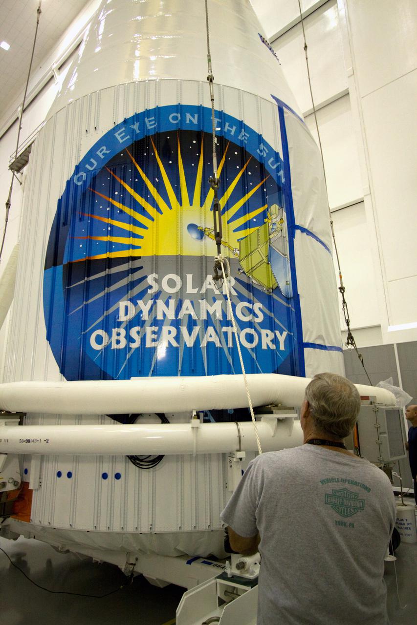 CAPE CANAVERAL, Fla. – At the Astrotech Space Operations facility in Titusville, Fla., the logo on the outside of the Atlas V payload fairing identifies the spacecraft enclosed within as NASA's Solar Dynamics Observatory, or SDO.  Workers are preparing to lift SDO onto a transporter in the airlock.  SDO is the first mission in NASA's Living With a Star Program and is designed to study the causes of solar variability and its impacts on Earth. The spacecraft's long-term measurements will give solar scientists in-depth information to help characterize the interior of the Sun, the Sun's magnetic field, the hot plasma of the solar corona, and the density of radiation that creates the ionosphere of the planets. The information will be used to create better forecasts of space weather needed to protect the aircraft, satellites and astronauts living and working in space. Liftoff aboard an Atlas V rocket is targeted for Feb. 9 from Launch Complex 41 on Cape Canaveral Air Force Station. For information on SDO, visit http:__www.nasa.gov_sdo.  Photo credit: NASA_Jack Pfaller